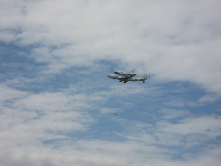 A side view of Discovery, the transport plane, and the escort.