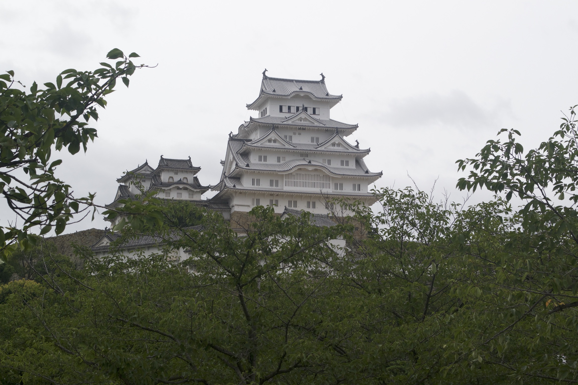 A black and white tiered castle stands against a gray sky.